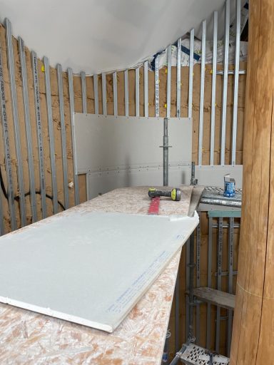 Espace de travail avec des murs en bois, un plan de travail et des outils de construction.